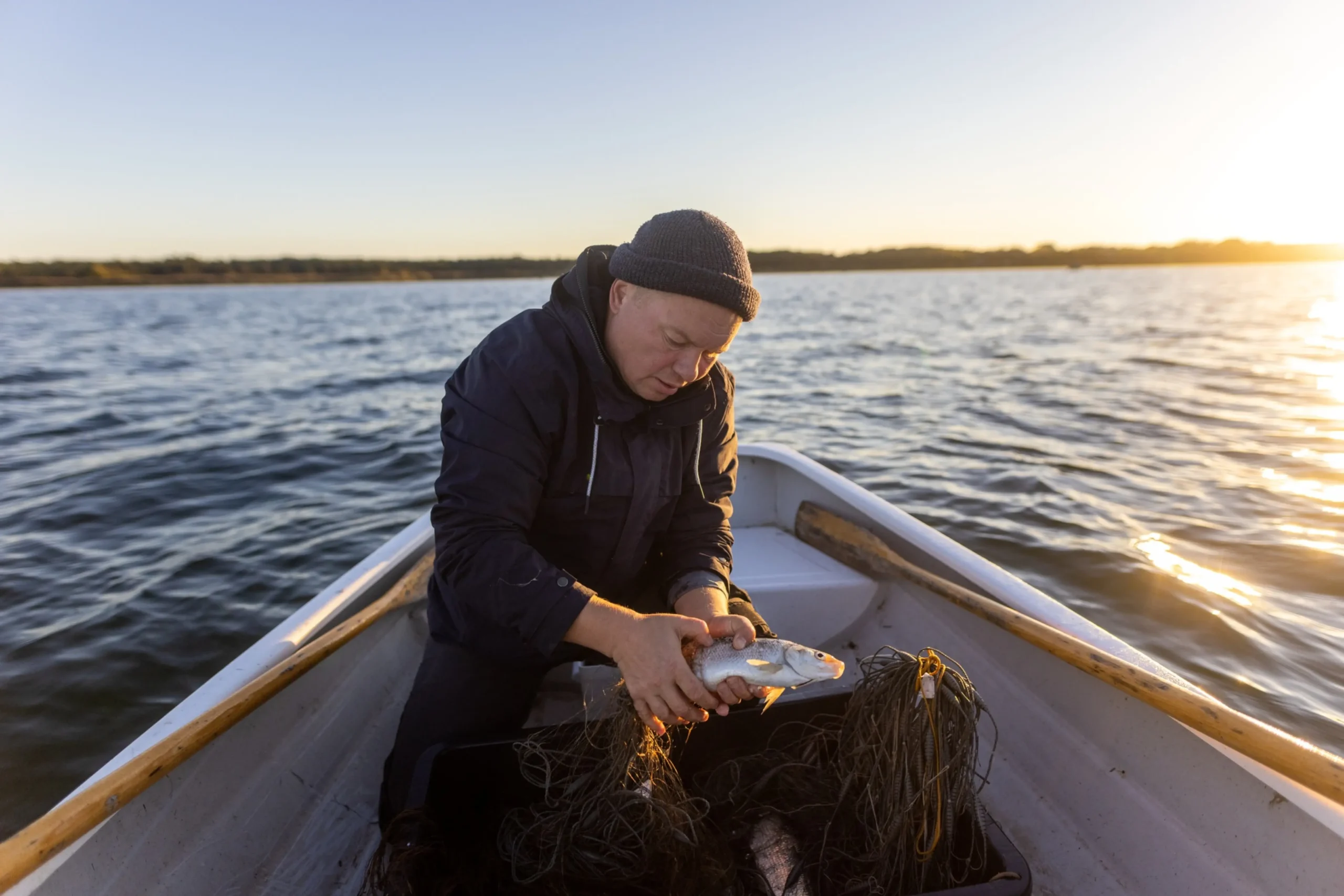 Fisherman holding fish on a boat_Renee Altrov 2